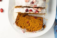 two slices of cake on a plate with icing and cranberry toppings