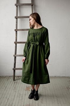 Victorian dress is made from 100% soft and washed linen. Details: - Colour: Forest green - Composition: 100% Oeko-Tex certified linen - Grey ribbon in the back - Ruffled long sleeves - Pockets - Belt included - Medium weight linen - Linen care: machine wash gentle; tumble dry low, ironing optional - The price is for one dress, other pictured items are not included Dark Green Linen Dress, Green Linen Dress For Fall, Spring Olive Linen Dress, Green Linen Daywear Dress, Green Linen Dress For Daywear, Green Linen Dresses For Fall, Green Relaxed Fit Linen Dress, Green Victorian Dress, Victorian Aprons