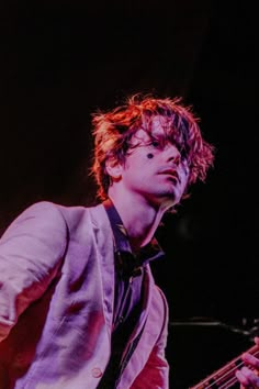 a young man playing a bass guitar on stage