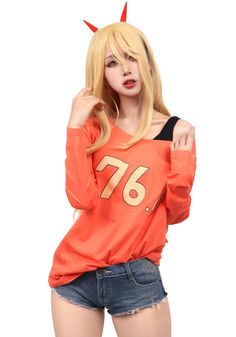 a woman in an orange shirt with horns on her head is posing for the camera