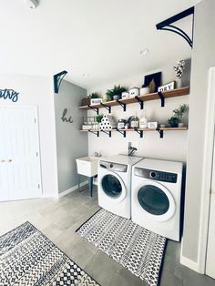 a washer and dryer sitting in a room next to a wall with shelves