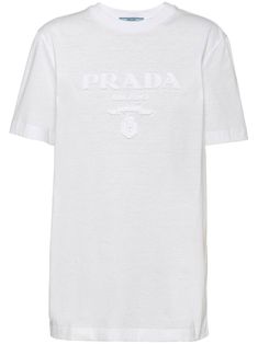 logo-appliqué cotton T-shirt from PRADA featuring white, cotton, jersey knit, appliqué logo, crew neck, short sleeves and straight hem. Designer Short Sleeve T-shirt With Logo Detail, Designer Short Sleeve Cotton T-shirt, Designer Cotton Short Sleeve T-shirt, Cotton Graphic Tee With Appliqué Logo, Sporty Cotton T-shirt With Embroidered Logo, Cotton Graphic Tee With Logo Detail, Cotton Jersey Logo Print Short Sleeve Tops, Short Sleeve Cotton Jersey Top With Logo Print, Cotton Jersey Short Sleeve Top With Logo Print