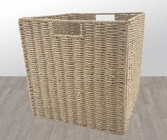 a large wicker basket sitting on top of a wooden floor next to a wall