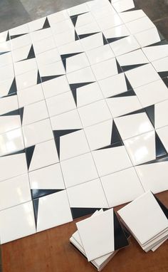 white and black tiles laid out on a wooden table with one folded up in the middle