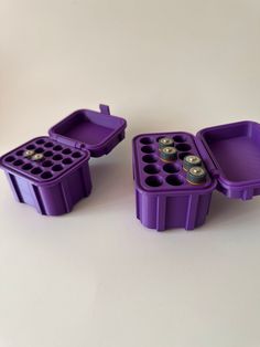 two purple trays filled with lots of different sized items next to each other on a white surface