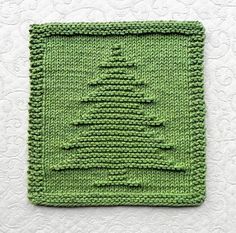 a green knitted square with a christmas tree on it