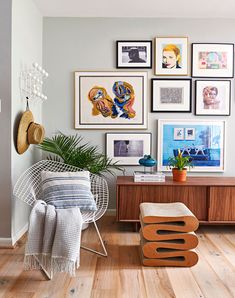 a living room with pictures on the wall and a chair in front of a table