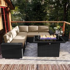 a couch and table on a deck with trees in the background