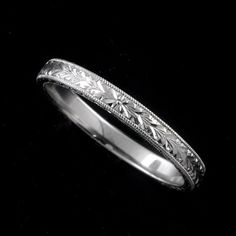 a wedding ring with filigrees and leaves on the side in white gold