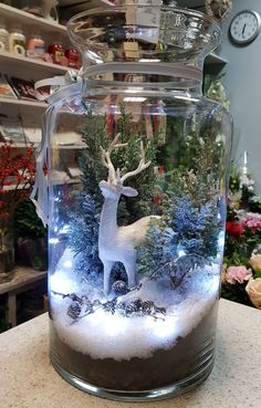 a glass jar filled with snow and christmas trees