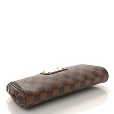 This is an authentic LOUIS VUITTON Damier Ebene Eva Clutch. This chic clutch is crafted of Louis Vuitton's signature checkerboard coated canvas in brown. The bag features a polished brass chainlink wristlet strap and a large gold-toned Louis Vuitton plaque on the front. The top zipper opens to a red fabric interior. Louis Vuitton Clutch, Louis Vuitton Empreinte, Louis Vuitton Damier Azur, Lv Monogram, Louis Vuitton Damier Ebene, Orange Bag, Damier Ebene, Louis Vuitton Shoulder Bag, Wallet Chain