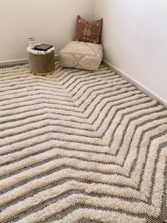 a room with a rug, chair and phone on the floor