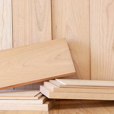 three pieces of wood stacked on top of each other in front of wooden planks