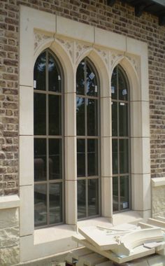 an old brick building with arched windows and stone work on the outside wall, in front of it