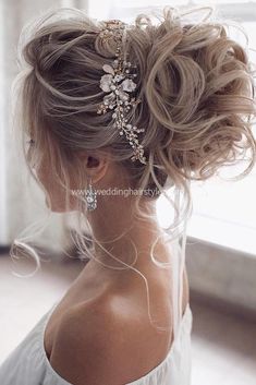 the back of a woman's head with long hair and flowers in her hair