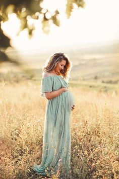 a pregnant woman is standing in a field