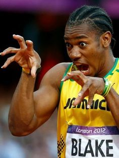 a man in a yellow shirt is holding his hands up and making a gesture with his hand