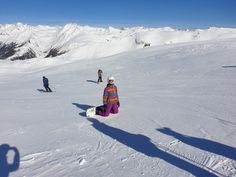 several people on skis in the snow with mountains in the backgroung