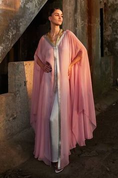 Pink satin organza kaftan with hand-embroidered metallic yarn neckline. Paired with an underlay in complementing color.
Components: 2
Neckline: V Neck
Sleeve Type: Cape
Fabric: Chiffon (100% Viscose), Satin (66% Viscose 34% Modal), Sequin (100% Plastic), Organza (100% Silk)
Color: Pink
Other Details: 
Length: 60 inches
Occasion: Party - Aza Fashions Organza Kaftan, Kaftan Women, Kaftan For Women, King Lear, Metallic Yarn, Pink Chiffon, Fashion App, Abaya Fashion, Modern Bride