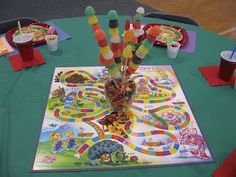 there is a game on the table with many candy sticks in it and cups around it