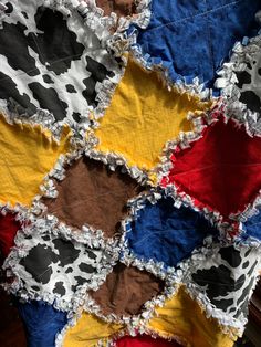 an old patchwork quilt with cow print and torn edges