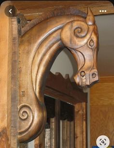 a wooden horse head mounted to the side of a wall next to a book shelf