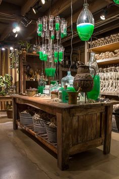 a room filled with lots of green glass vases and skeleton figurines hanging from the ceiling