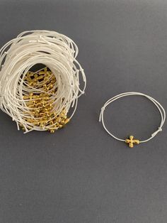 "Martyrika-Witness Bracelets- Greek Orthodox Baptism Gold Cross Wax Cord bracelets come packaged in a giftbox. What you see in the photos are samples; I will re-create your bracelets as close as I can to what you see, or in any variation you would like. Martyrika is a Greek word which means '\"sign of witnessing\". Traditionally in Greek Orthodox Baptisms, Martyrika bracelets are given to the guests upon arrival at the church as an honour for attending and witnessing a Baptism. Items sent via US White Spiritual Jewelry For Gifts, Hypoallergenic White Jewelry For Baptism, White Bracelet Jewelry For First Communion, White Bracelet For First Communion, Spiritual Cross Bracelet For First Communion, Adjustable White Rosary Bracelet Gift, Adjustable Cross Bracelets For Baptism, Adjustable White Jewelry For Blessing, Gold Cross Bracelet For Baptism