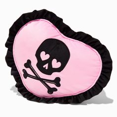 a heart shaped pillow with a skull and crossbones on the front in pink