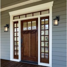 the front door of a house with two sidelights on it and wood flooring