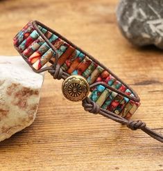 a bracelet that is sitting on top of a table next to a rock and some rocks