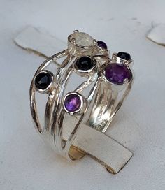 **FREE EXPRESS SHIPPING** Thank you for taking the time to visit my store I'm a jewelry designer for 23 years I am full of giving ,love and positive energies and there is nothing that makes me happier than helping people and making them happy So I put all these energies into my jewelry and when you wear them you will feel it with a lot of love 💖 Sterling Silver ring made of yarns With seven gemstones Five 3 mm amethyst citrine and peridot And two 5 mm Blue Topaz and Moonstone Ring width at the Sterling Silver Multi-stone Moonstone Ring, Elegant Silver Stackable Rings With Natural Stones, Sterling Silver Stackable Rings With Natural Stones, Fusion Style Multi-stone Round Rings, Round Sapphire Fusion Ring, Unique Amethyst Ring With Accent Stones, Artisan Rings With Stones, Unique Multi-stone Moonstone Ring Gift, Sterling Silver Round Moonstone Fusion Ring