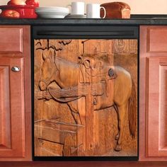 a wooden carving of a horse on a kitchen cabinet door with apples in the background