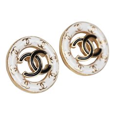 These Chanel CC round stud earrings feature a gold tone round cut-out detail stud earring with white enamel trim accented with mini gold tone CC's and one large black enamel CC logo in the center with post back closures.Origin: ItalyCondition: New and never wornAccompanied by: Chanel box, jewelry box, carebook, retail UPCMeasurements: 0.6" x 0.6" Luxury White Pierced Earrings, Luxury Yellow Gold Enamel Earrings, Designer Gold Round Earrings, Luxury White Enamel Earrings, Elegant Black Enamel Earrings, Formal White Jewelry With Black Enamel, Designer White Earrings For Formal Occasions, Classic Gold Enamel Earrings, Designer Gold Jewelry With Black Enamel