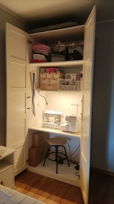 a sewing machine sits on top of a desk in the corner of a room with white walls