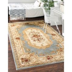 a large rug with an ornate design on the floor in front of a white bed