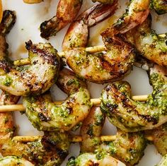 grilled shrimp and broccoli skewers with pesto sauce on them