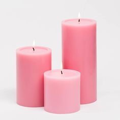 three pink candles sitting next to each other