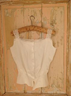 soft cotton camisole from the 1910s with lace straps and lovely tiny (glass) buttons at the front there is beautiful pin tuck work This top is hand made with doubled seams. waist 63 cm  24 3/4" bust 92 cm 36" I saw a little grey mark at the front (see photo 2) Fitted Cami Blouse For Daywear, Fitted Camisole Blouse For Daywear, Victorian Cotton Tops With Lace Trim, Victorian Cotton Top With Lace Trim, Victorian Cotton Tops For Summer, Vintage Cami Top For Daywear, Fitted Vintage Cotton Lace Tops, Vintage Lace Trim Camisole Top, Vintage Lace Top Camisole For Summer