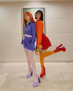 two women dressed in costumes standing next to each other