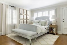 a bedroom with white walls and wood floors