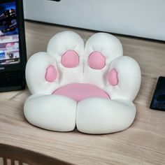 a cell phone sitting on top of a table next to a fake animal's paw