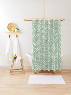 a bathroom with a green shower curtain next to a white bath tub and wooden stools