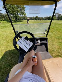 a person sitting in a golf cart with their feet on the driver's wheel