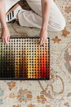 a person sitting on the floor with an array of colors