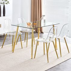 a glass dining table with gold legs and clear chairs in a white living room area