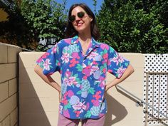 "This rad take on a Hawaiian shirt is in comfortable cotton with an allover pattern of hibiscus flowers and fruit including sea green pineapples, lavender pears, mauve plums, and indeterminate red orbs. It has a button and loop collar, which is pretty cool.  Styled with 1980s Levi's available here: https://www.etsy.com/listing/1571285449/1980s-lavender-levis-jeans-550-relaxed   47\" chest  27.5\" length Modern size Large/XL Vintage size men's M per tag Sizes as listed on Etsy are my best guess P Vintage Hawaiian Shirts 50s, Vintage Multicolor Hawaiian Shirt, Pink Hawaiian Shirt, Hawaiian Button-up Shirt With Hibiscus Print For Vacation, Retro Printed Button-up Hawaiian Shirt, Blue Retro Hawaiian Button-up Shirt, Hibiscus Flowers, Levis Jeans, Hawaiian Shirt