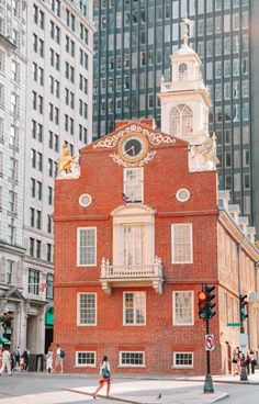 an old red brick building with a clock tower on top in the middle of a city