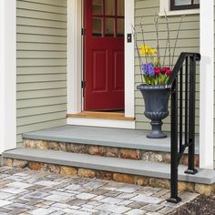 a vase with flowers sitting on the front steps