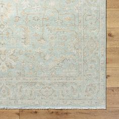 a light blue and beige rug on a wooden floor